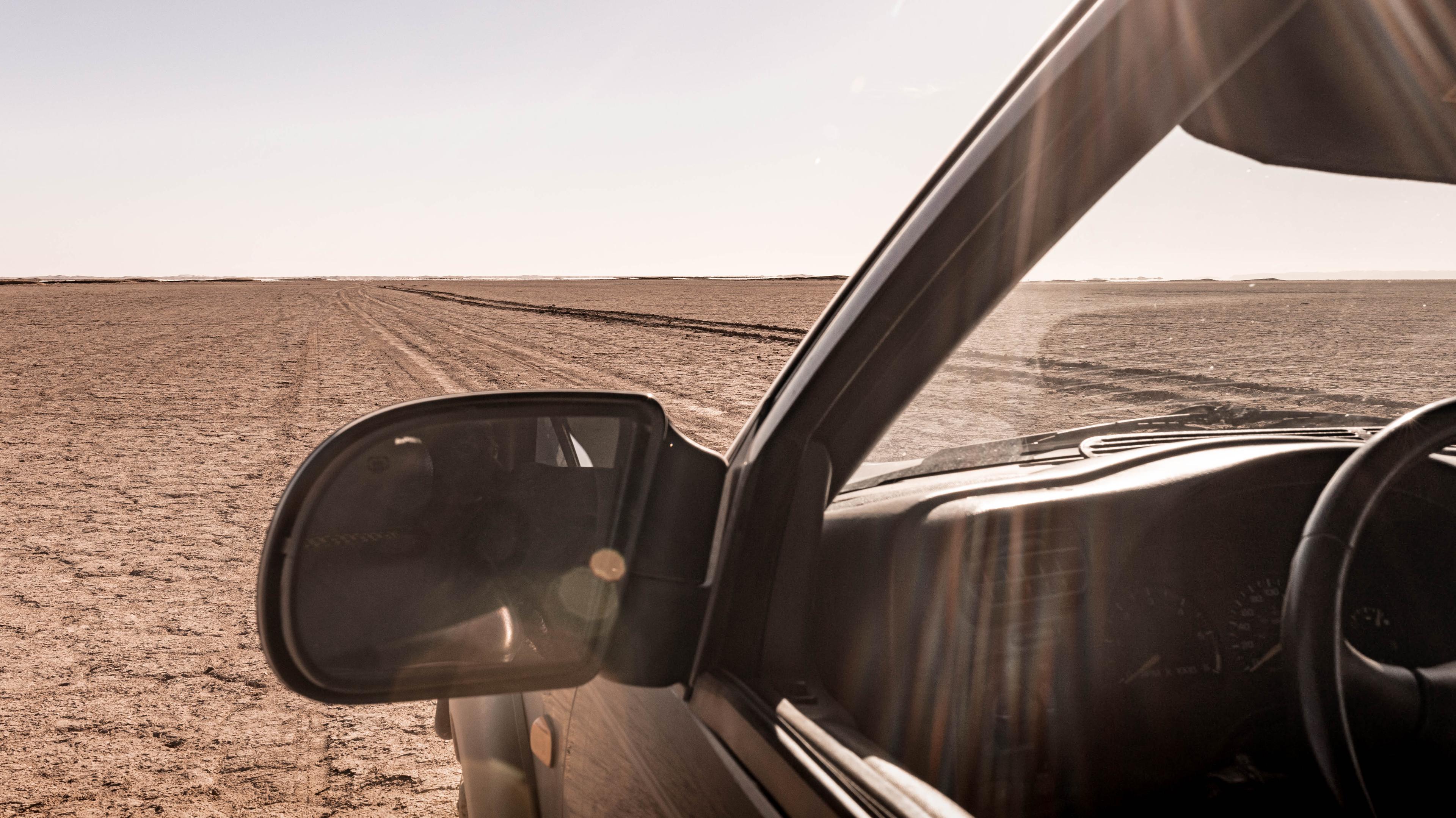 View from the driver’s seat of Anne’s Chevy across the dry Lake Iriki in Morocco, symbolizing facing real terrain with your AppSec program instead of assuming a smooth road ahead.