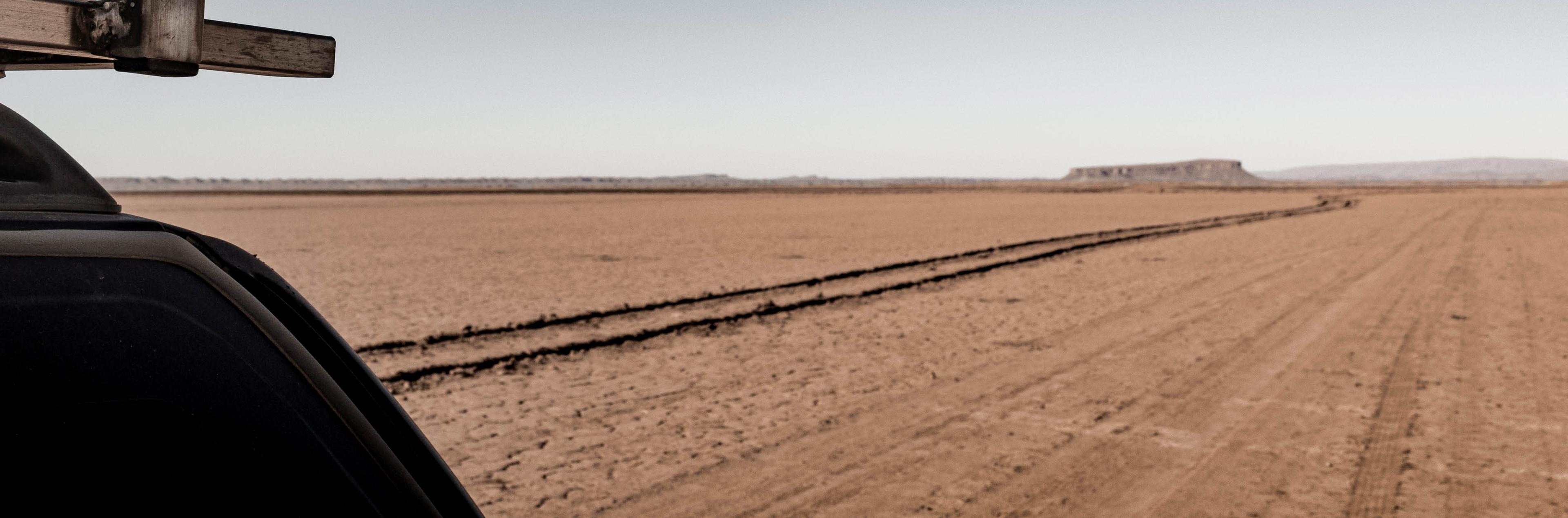 View from beside Anne’s Chevy across the dry Lake Iriki in Morocco, showing the off-road track already traveled.