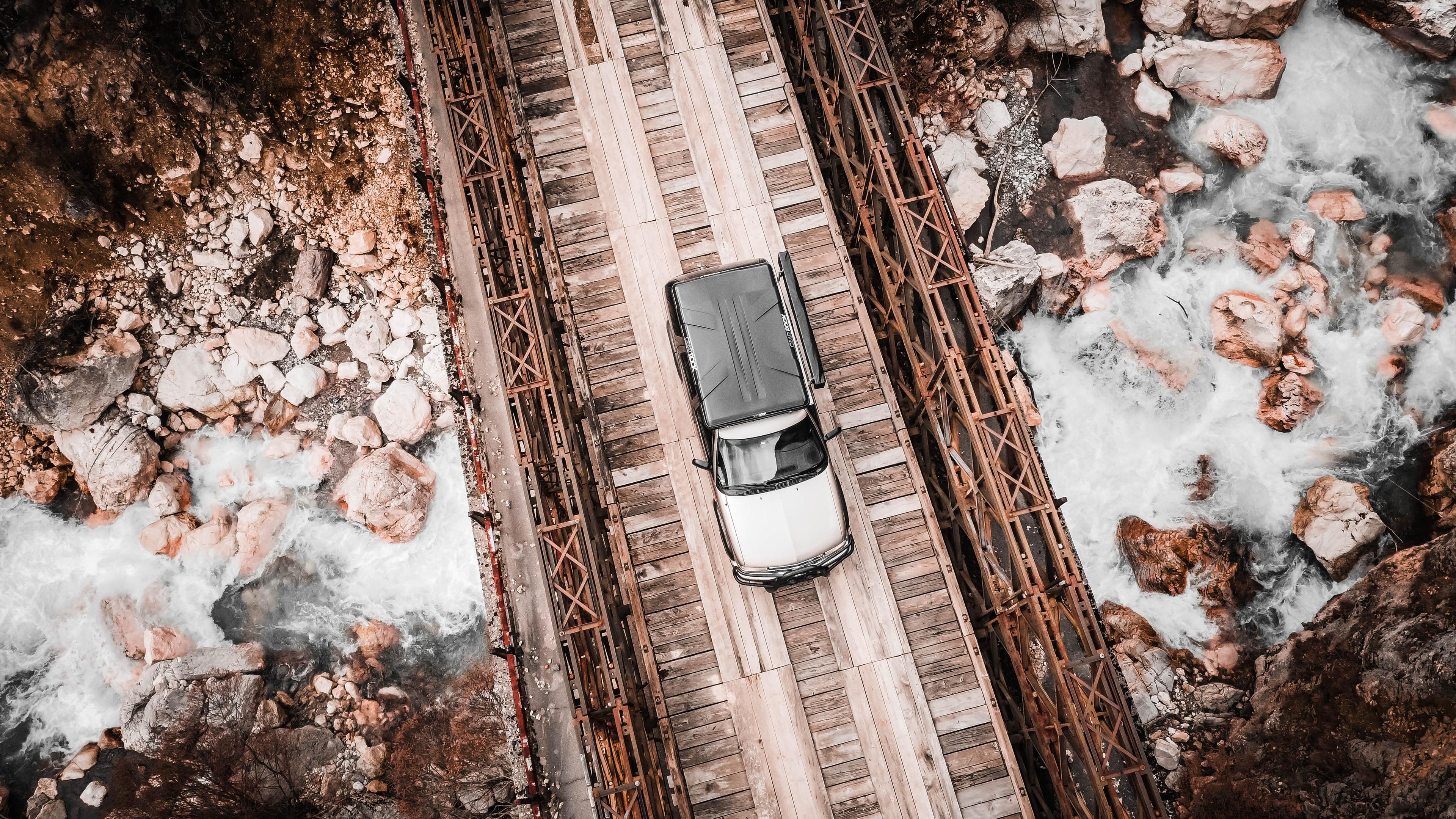 Chevy Blazer crossing a wooden bridge in the Bosnian mountains – symbolizing resilience and navigation through rough terrain.
