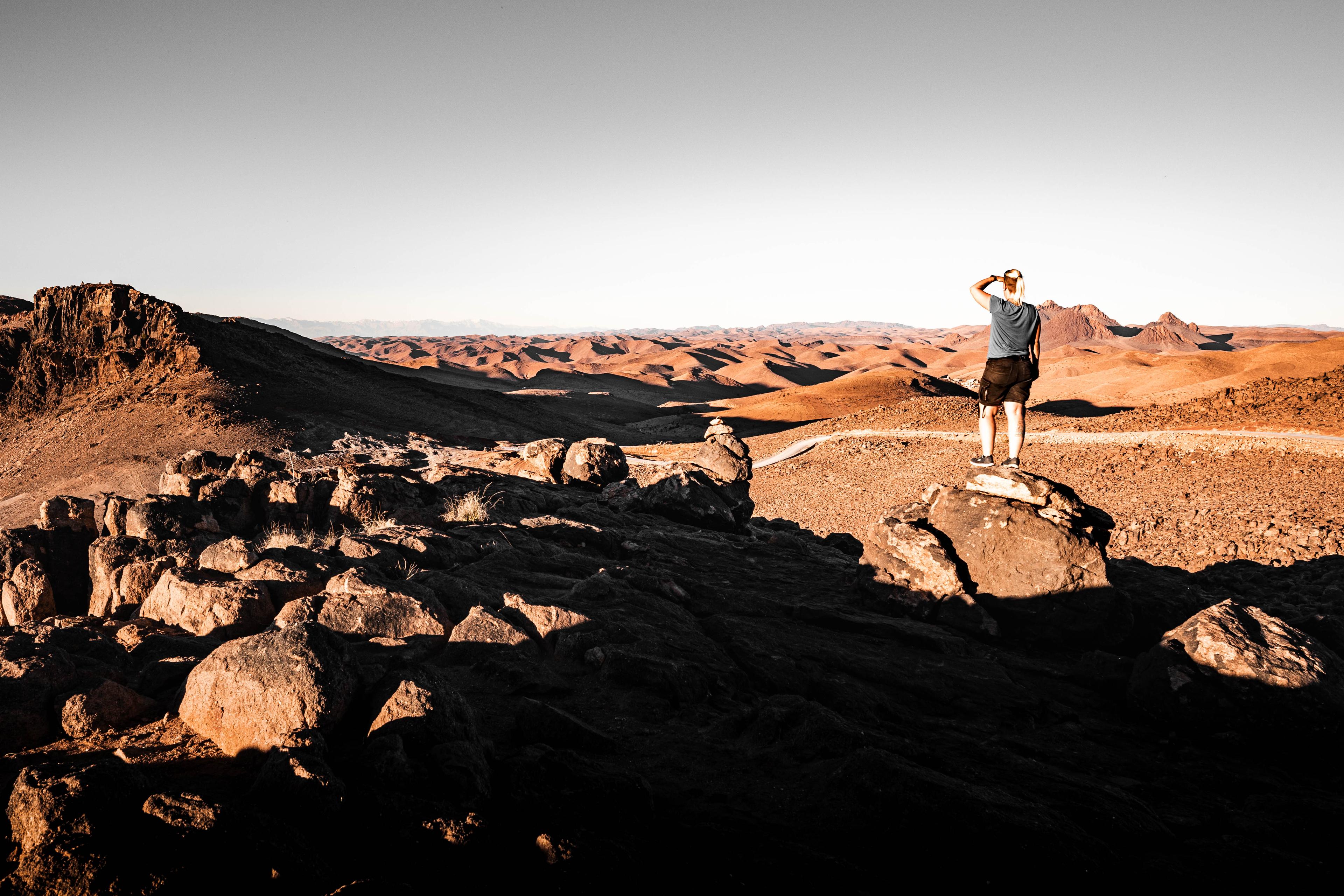 Anne standing on a rock in the Anti-Atlas mountains in Morocco, overlooking a wide rugged landscape that reflects the Terrain Check theme.