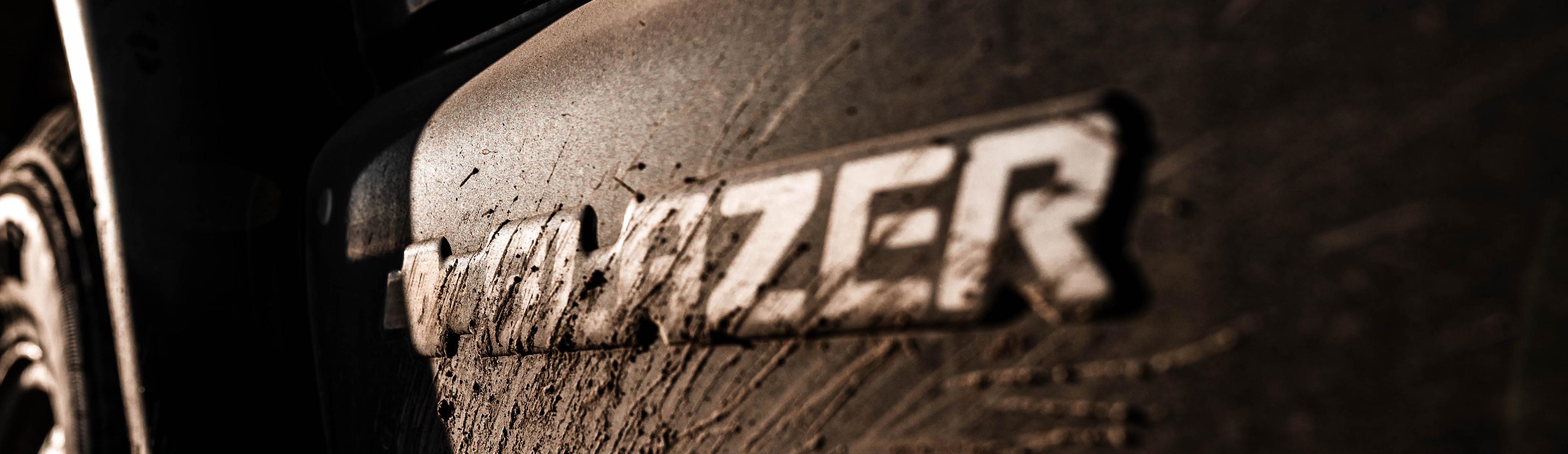 Close-up of a muddy Chevy Blazer emblem, representing AppSec ownership built for real-world conditions where things get messy.