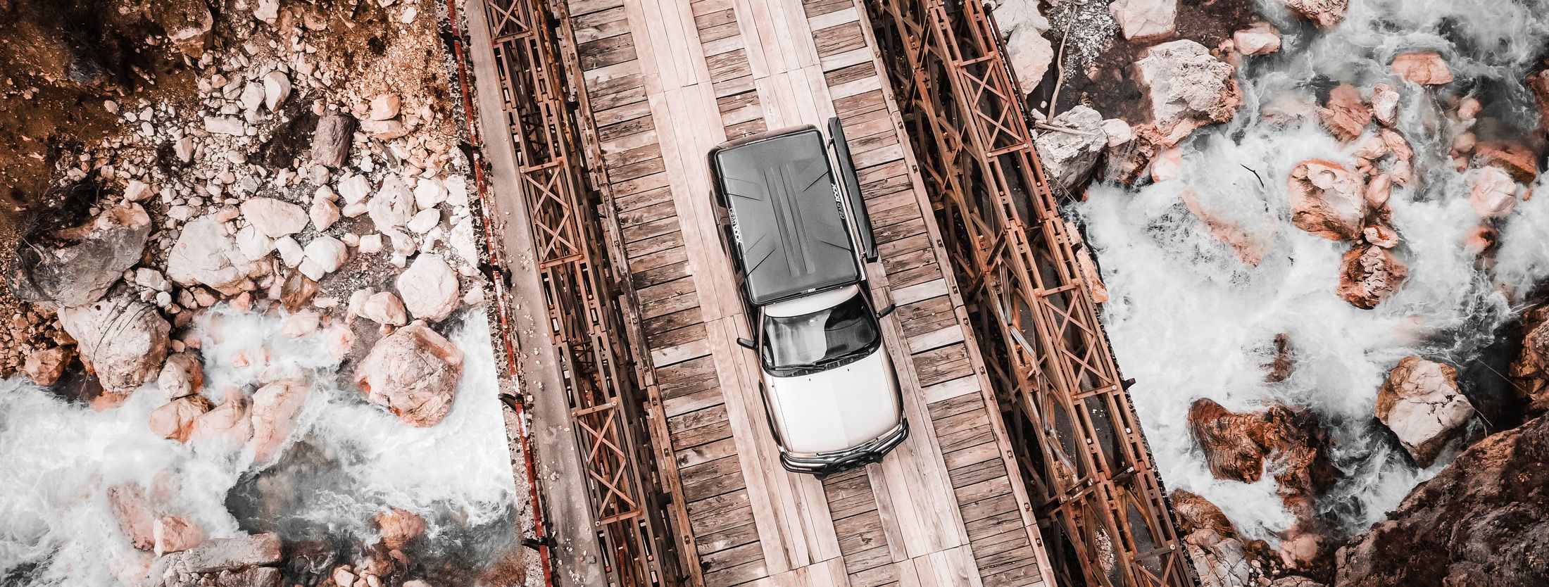 Crossing wild terrain – Chevy Blazer on an overlanding mission through Bosnia. Chevy Blazer crossing a wooden bridge in the Bosnian mountains – symbolizing resilience and navigation through rough terrain.