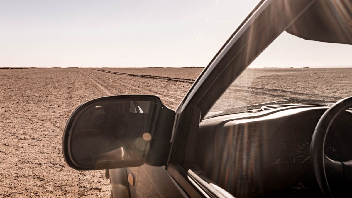 Take the driver’s seat View from the driver’s seat of Anne’s Chevy across the dry Lake Iriki in Morocco, symbolizing facing real terrain with your AppSec program instead of assuming a smooth road ahead.