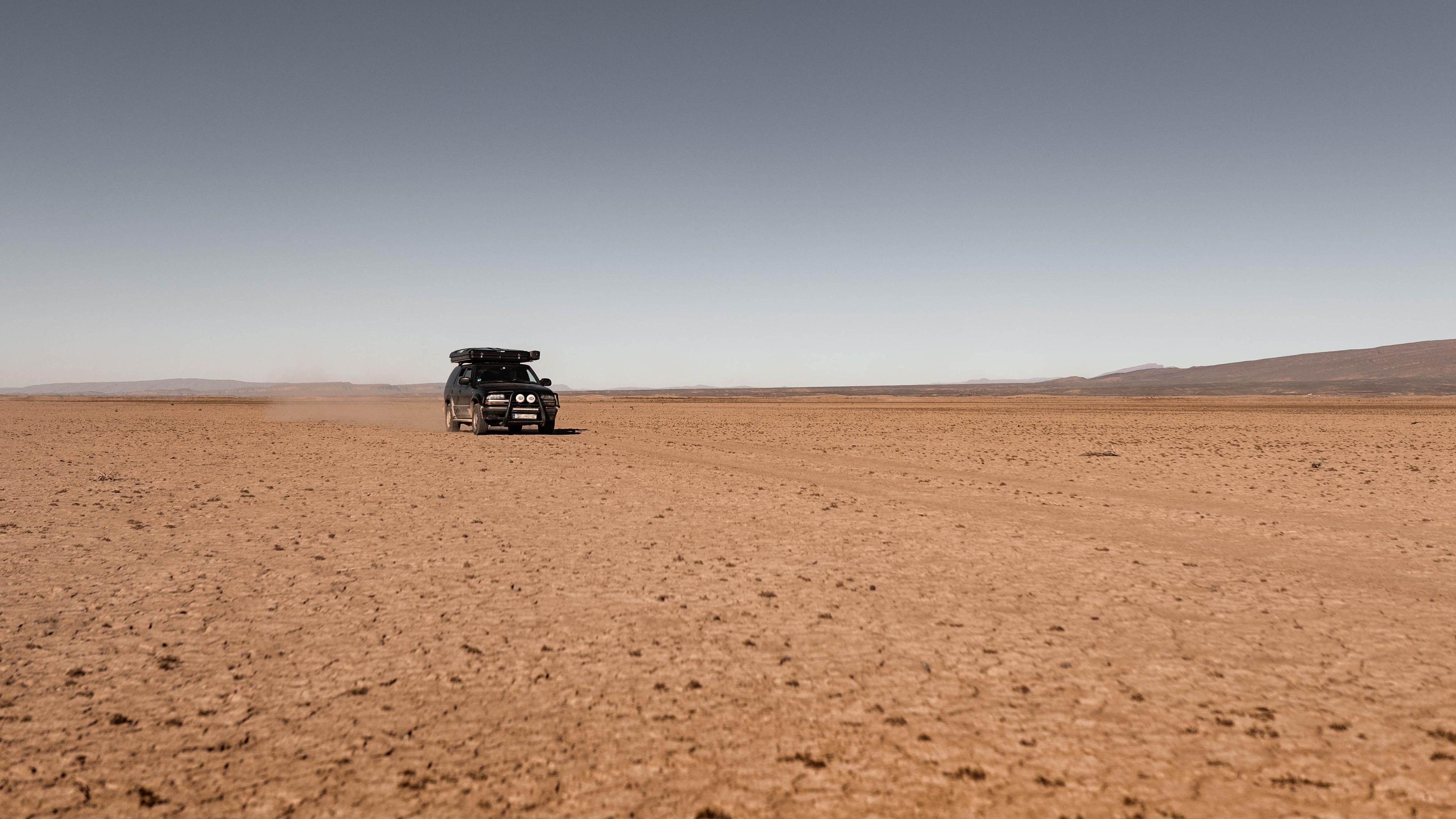 Anne's Blazer at Lake Iriki in Morocco 1999 Chevrolet S10 Blazer driving across the dry bed of Lake Iriki in Morocco with a dust cloud behind it.