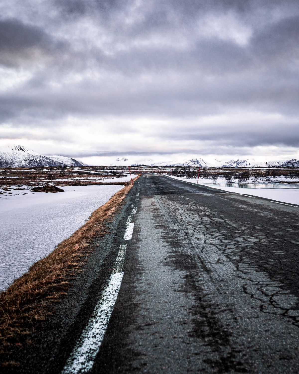 A paved road in northern Norway in winter. A paved road Anne did drive in northern Norway in winter representing the false assumption AppSec programs are built on.